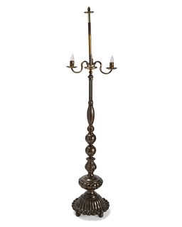 A tall patinated brass floor lamp