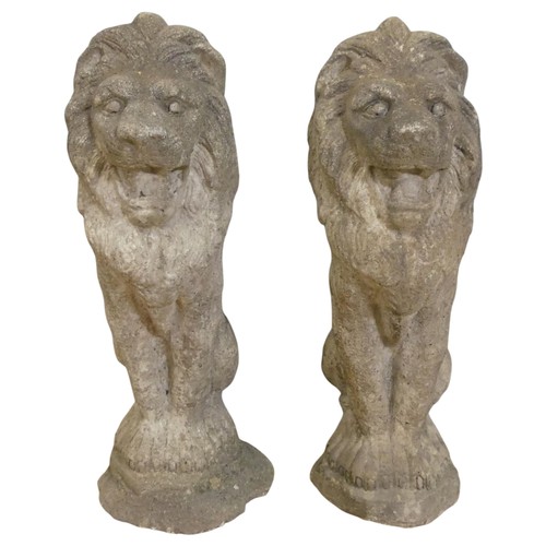 A pair of weathered concrete statues. St…